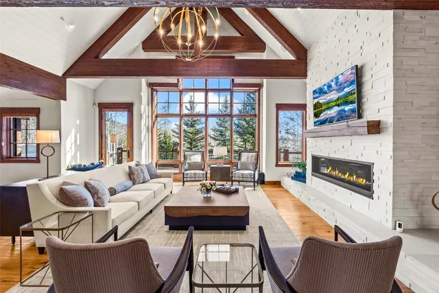 a living room with fireplace furniture and a large window