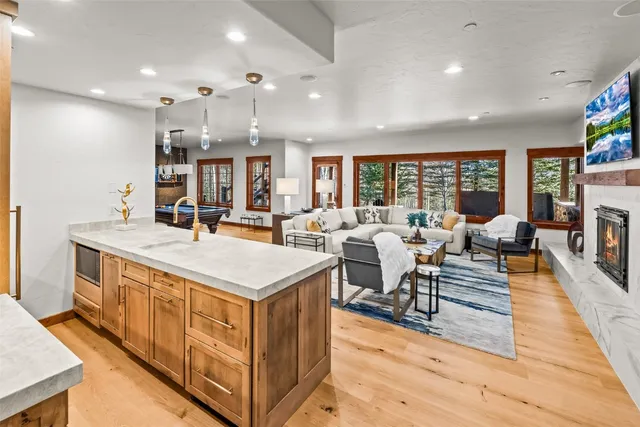 a large kitchen with stainless steel appliances a large counter top a stove and a sink