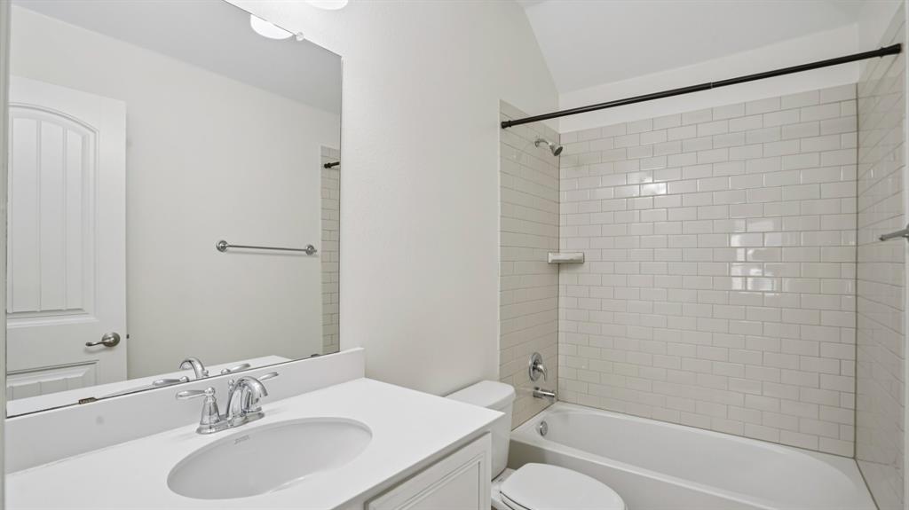 9904 Copperhead Lane McKinney, TX 75071 - Photo 29 of 40 Bathroom featuring shower combination, vanity, and lofted ceiling