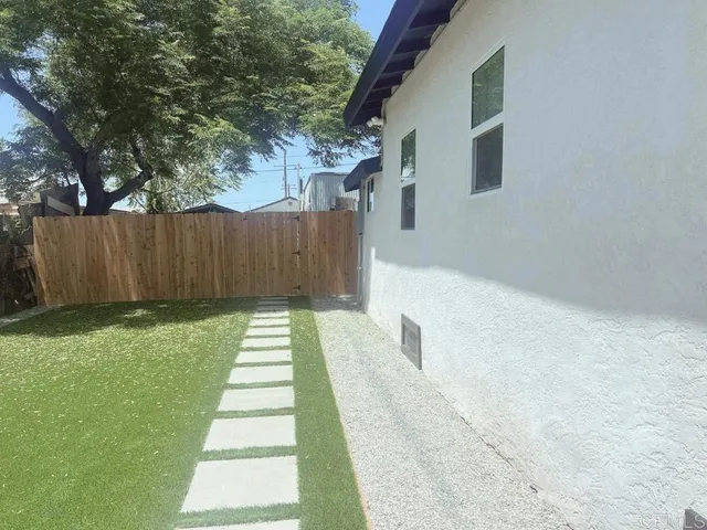 a view of backyard with wooden fence