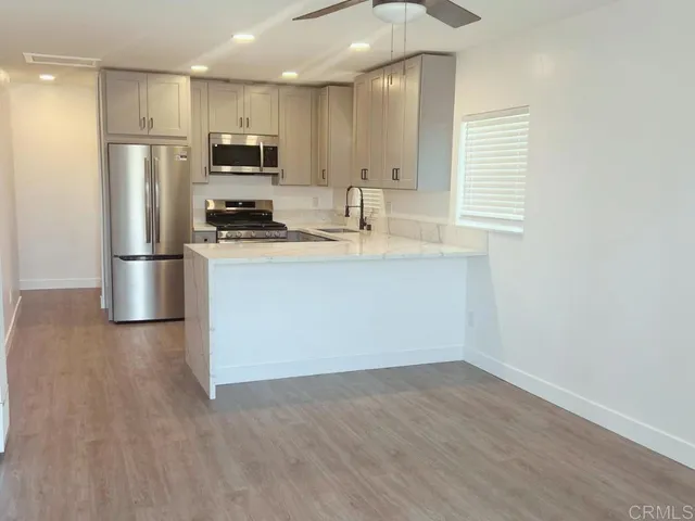 a kitchen with stainless steel appliances a refrigerator and a stove top oven