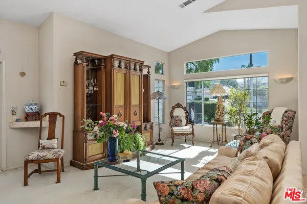 a living room with furniture a rug and a chandelier