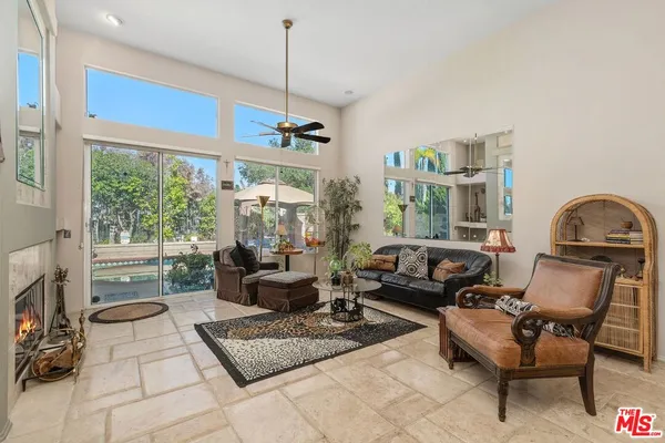 a view of a dining room and livingroom with furniture wooden floor a chandelier