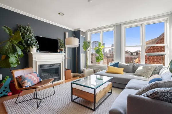 a living room with furniture a flat screen tv and a fireplace