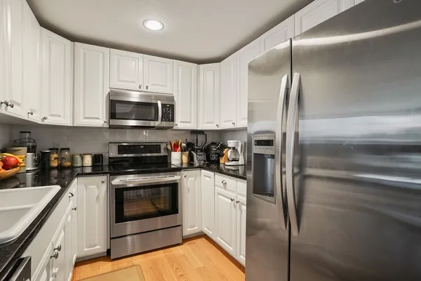 a kitchen with cabinets stainless steel appliances and a counter top space