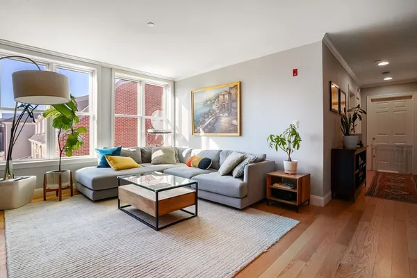 a living room with furniture and a wooden floor