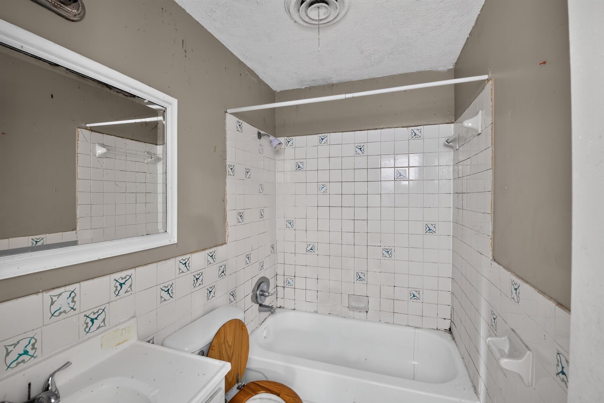 3791 Windermere Road Memphis, TN 38128 - Photo 16 of 18 Bathroom featuring a white porcelain tub, white tiled surround with blue accent tiles, and a white vanity with an integrated sink