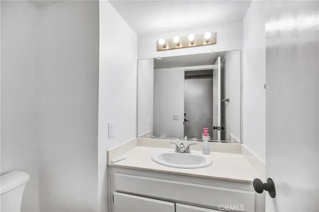 a bathroom with a sink and a mirror with toilet