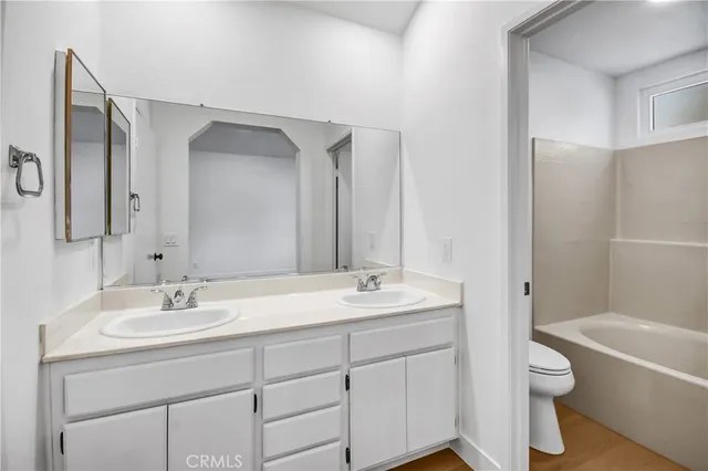 a bathroom with a granite countertop sink a toilet and a bathtub