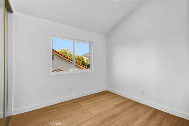 a view of a room with wooden floor and a window