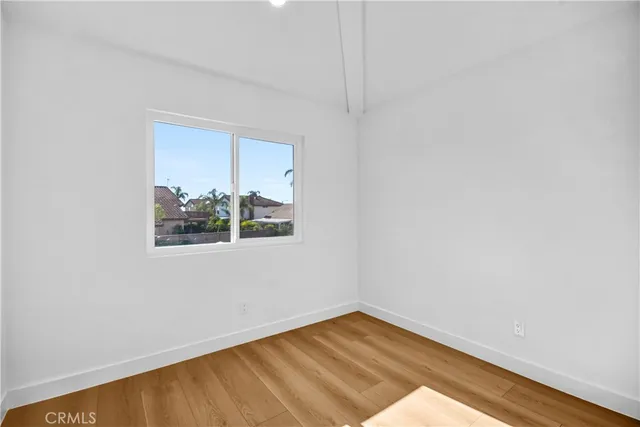 a view of a small space with wooden floor and a window