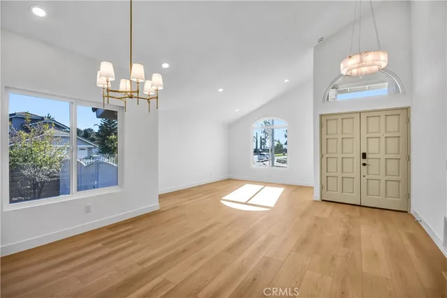 a view of a room with wooden floor chandelier and entryway