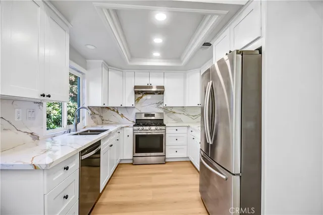 a kitchen with stainless steel appliances a refrigerator sink and stove