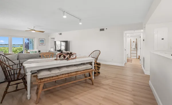 a living room with furniture and a dining table with kitchen view