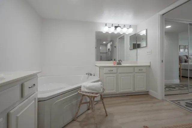 a bed sitting in a spacious bedroom next to a window