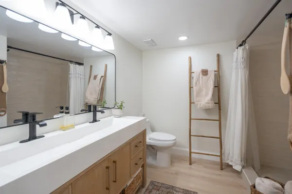 a spacious bedroom with two beds and painting on the wall