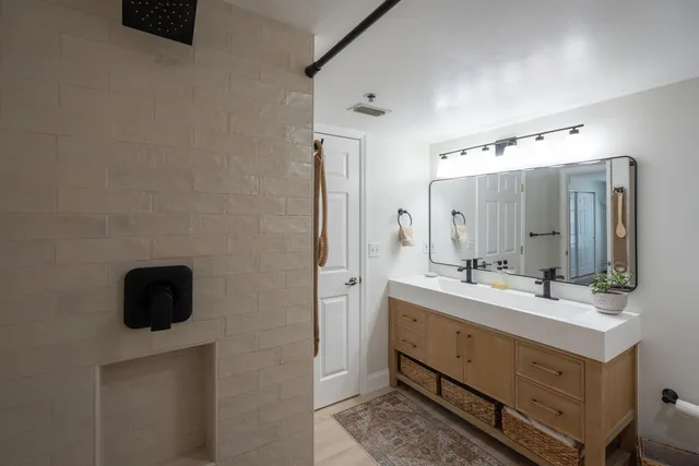 a bathroom with a double vanity sink toilet and shower