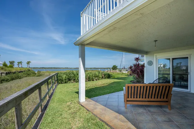 a view of a patio with couple of chairs and a potted plant