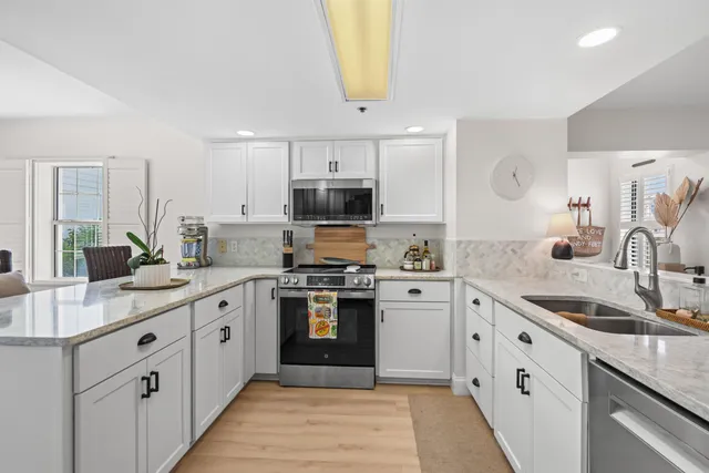 a kitchen with stainless steel appliances granite countertop a sink and dishwasher a stove top oven with wooden floor