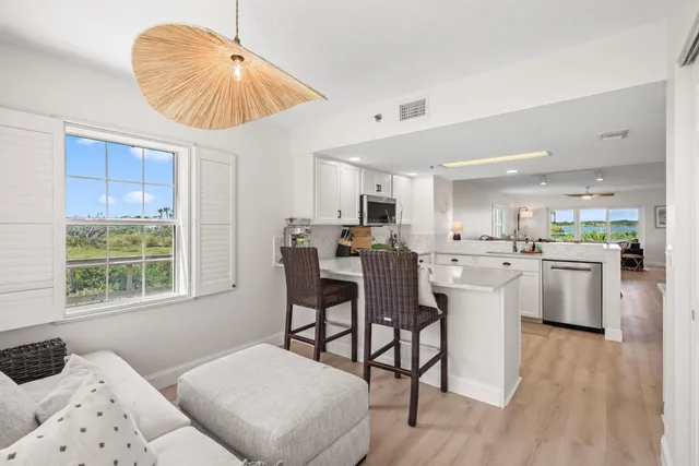 a kitchen with kitchen island a counter top space wooden floor and stainless steel appliances