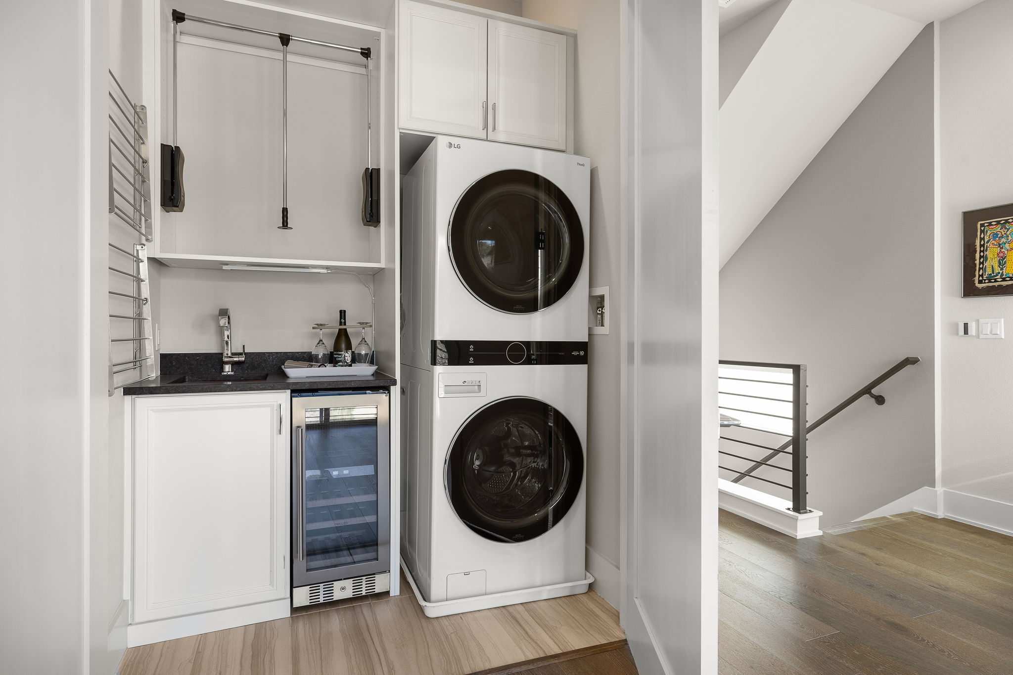 5214 Pink Poppy Pass Austin, TX 78735 - Photo 28 of 34 Laundry area featuring wine cooler, stacked washer / dryer, light wood finished floors, and bar