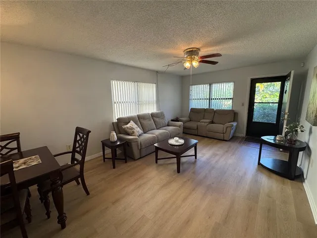 a living room with furniture two window and a flat screen tv