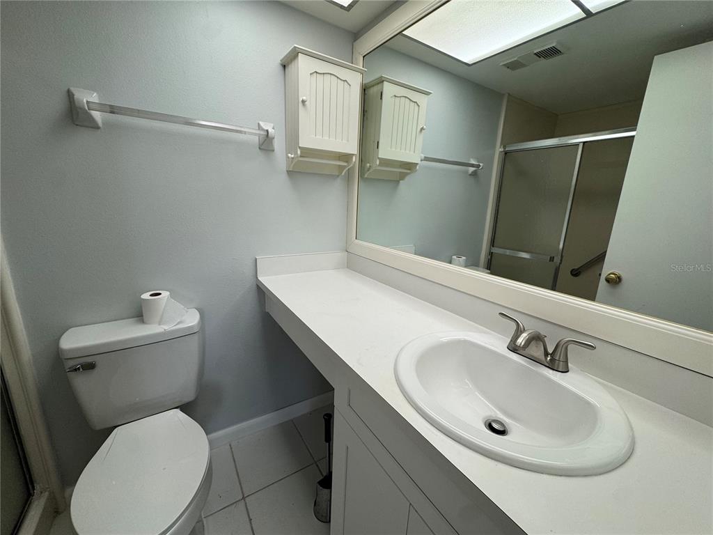 315 30th Avenue West, Unit 101B Bradenton, FL 34205 - Photo 8 of 20 a bathroom with a toilet sink and mirror