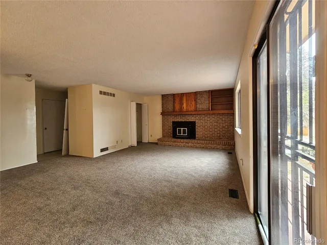 an empty room with fireplace and a window