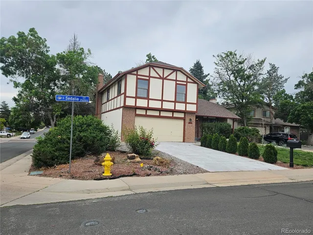 a front view of a house with a yard and potted plants
