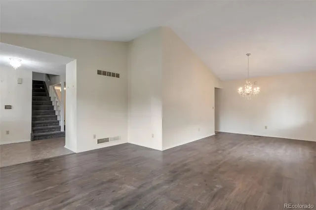 an empty room with wooden floor and natural light