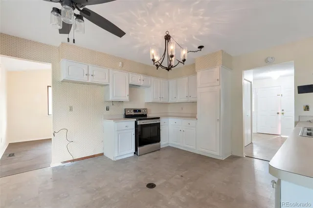 a kitchen with a refrigerator a stove top oven a sink and cabinets