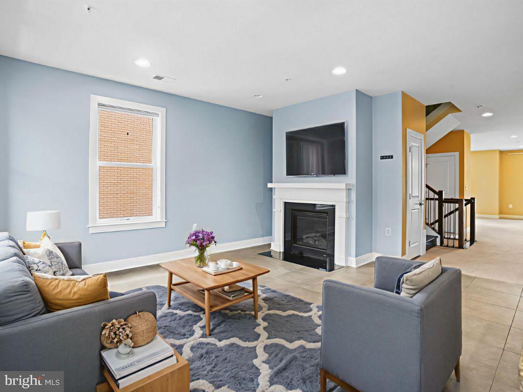 1901 Main Line Boulevard, Unit 102 Alexandria, VA 22301 - Photo 11 of 34 a living room with furniture a rug and a fireplace