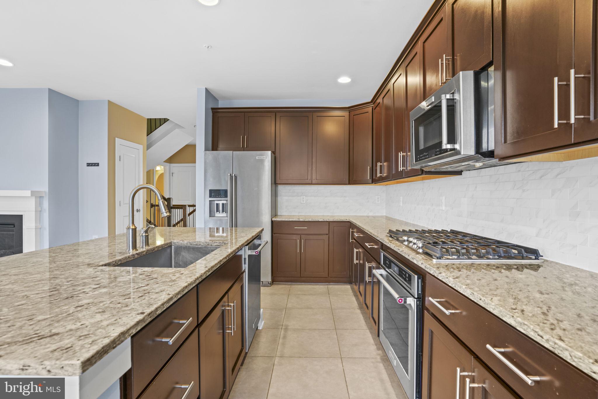 1901 Main Line Boulevard, Unit 102 Alexandria, VA 22301 - Photo 7 of 34 a kitchen with granite countertop a sink stove and cabinets