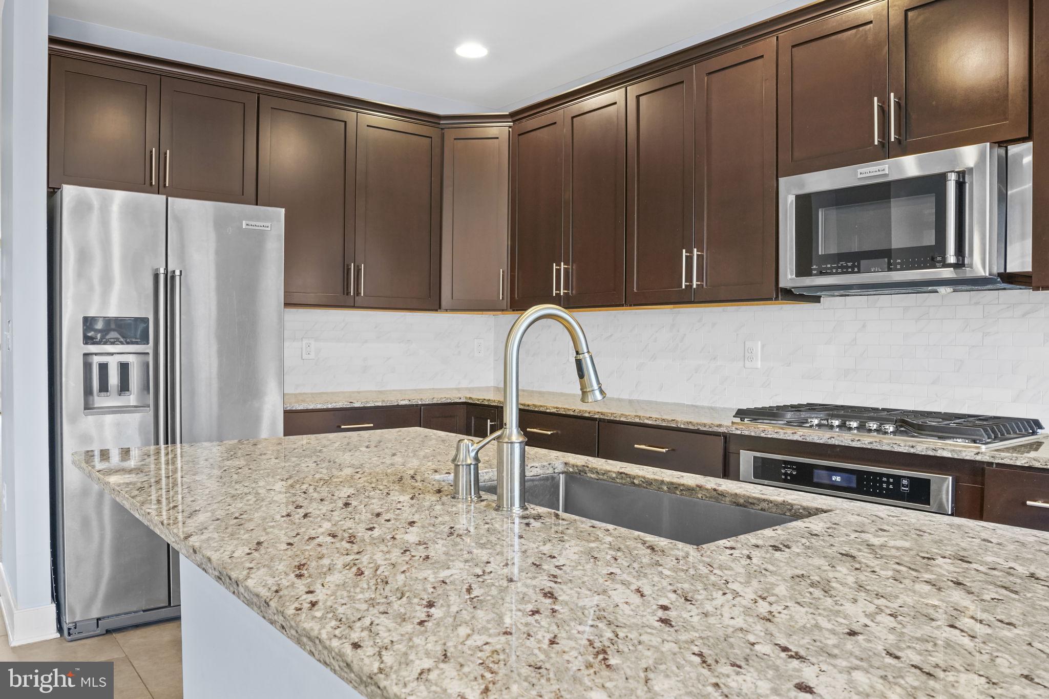 1901 Main Line Boulevard, Unit 102 Alexandria, VA 22301 - Photo 9 of 34 a kitchen with stainless steel appliances kitchen island a cabinets sink and microwave