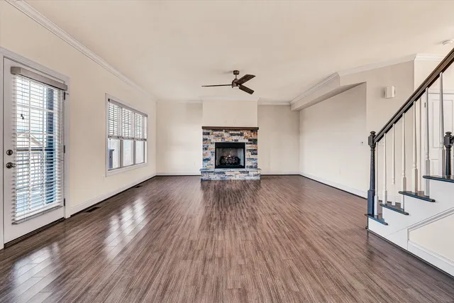 a view of a livingroom with wooden floor fireplace and a window