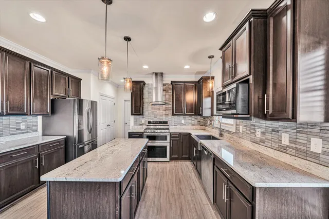 a kitchen with stainless steel appliances granite countertop a sink stove and refrigerator