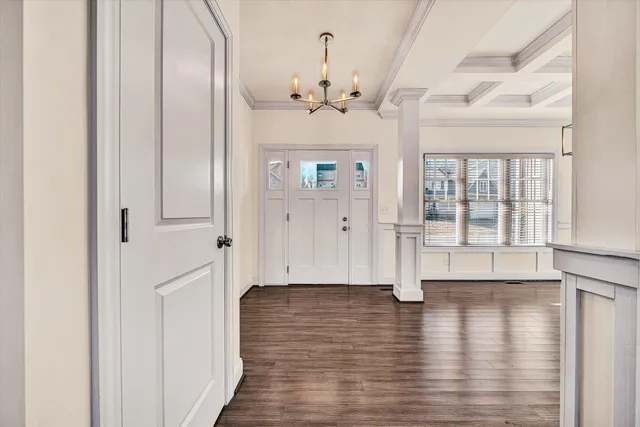 a view of a hallway with wooden floor windows and a chandelier