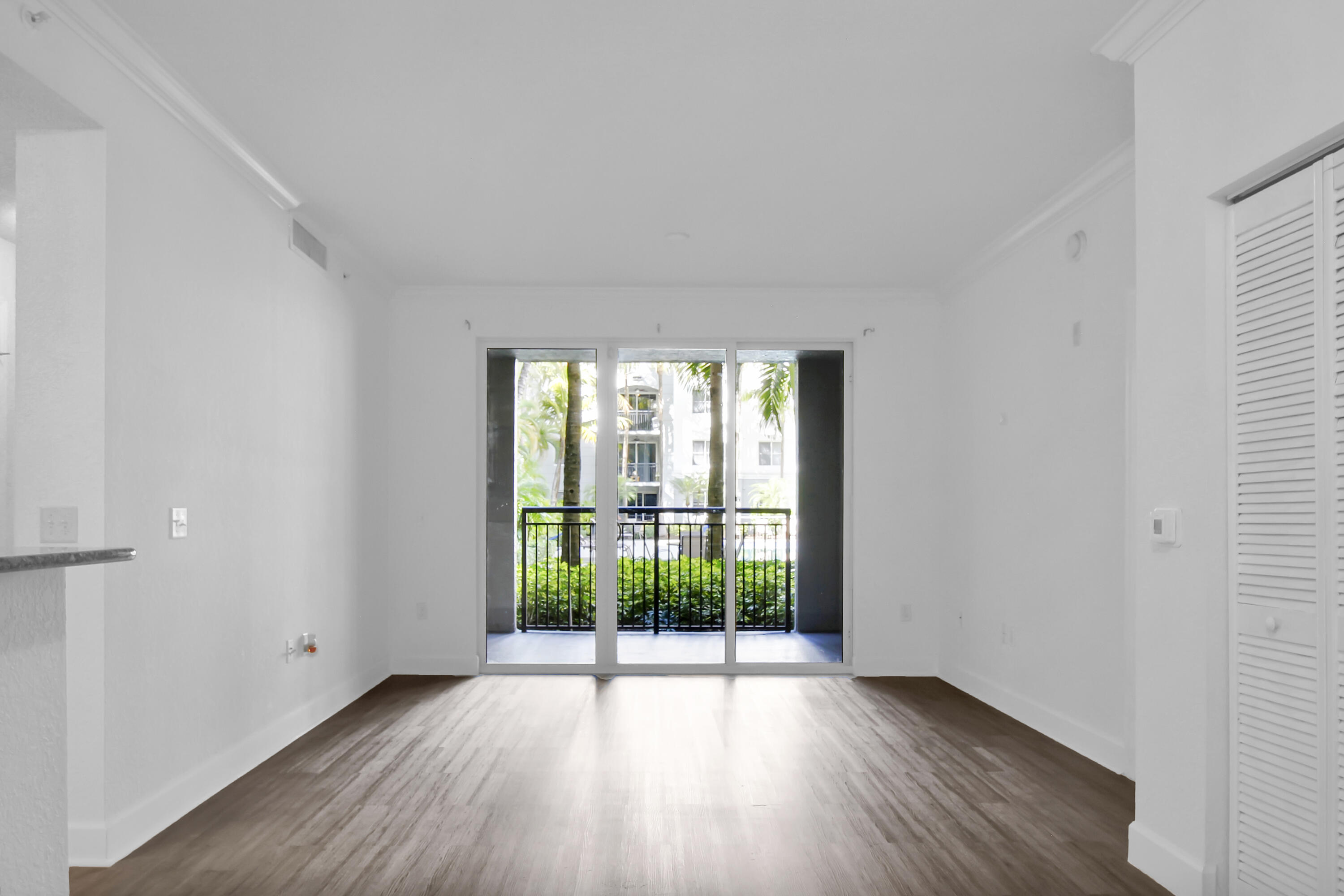 1660 Renaissance Commons Boulevard, Unit 2122 Boynton Beach, FL 33426 - Photo 23 of 38 a view of an empty room with wooden floor and a window