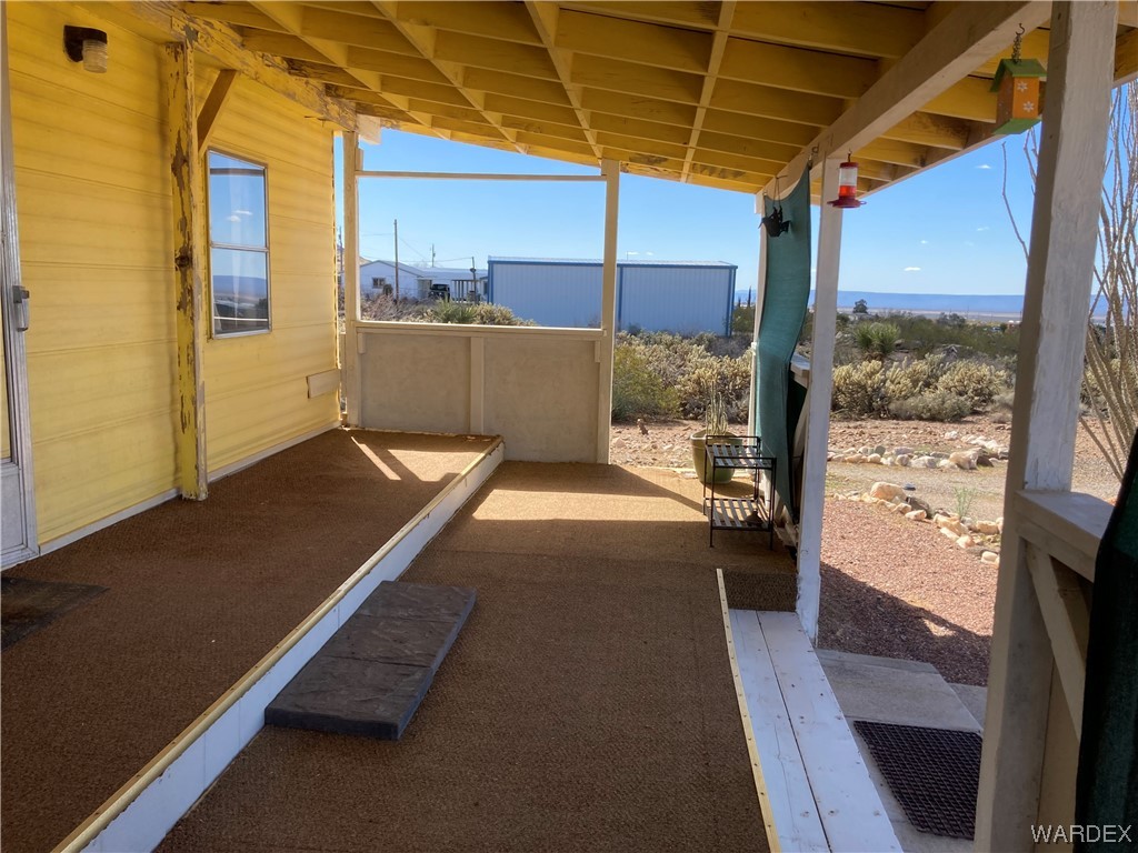 3460 Bouse Road Golden Valley, AZ 86413 - Photo 7 of 79 a view of a balcony with a table and chairs