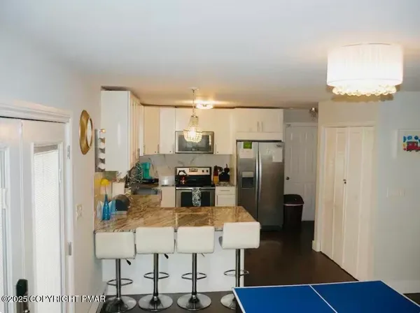 a kitchen with stainless steel appliances a refrigerator and wooden floor