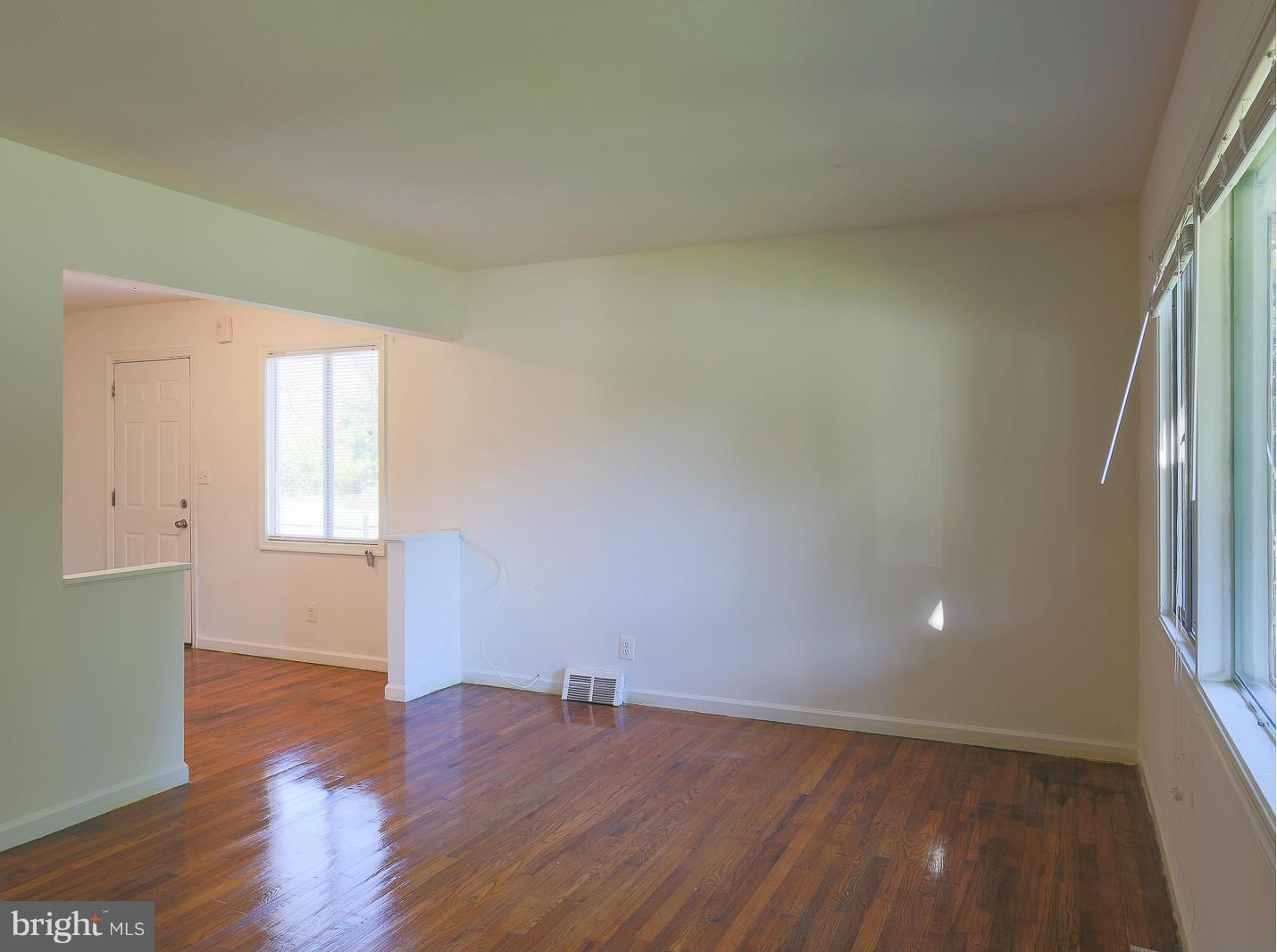 3114 Fairview Road Baltimore, MD 21207 - Photo 11 of 30 an empty room with wooden floor and windows