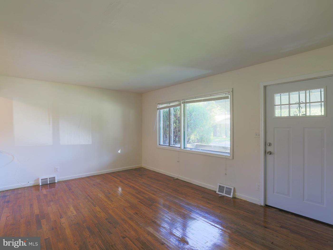 3114 Fairview Road Baltimore, MD 21207 - Photo 12 of 30 an empty room with wooden floor and windows