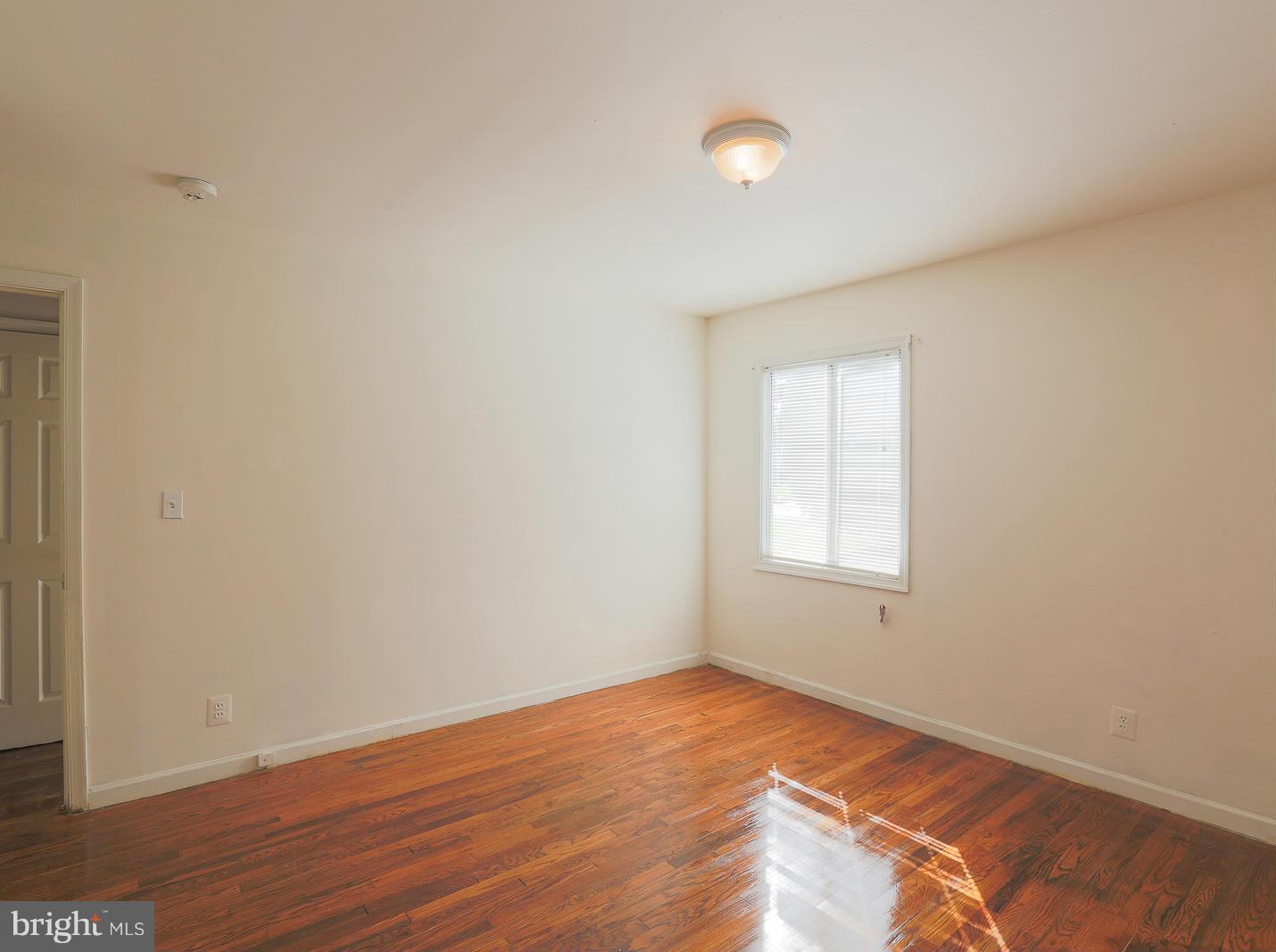3114 Fairview Road Baltimore, MD 21207 - Photo 20 of 30 a view of an empty room with wooden floor and a window