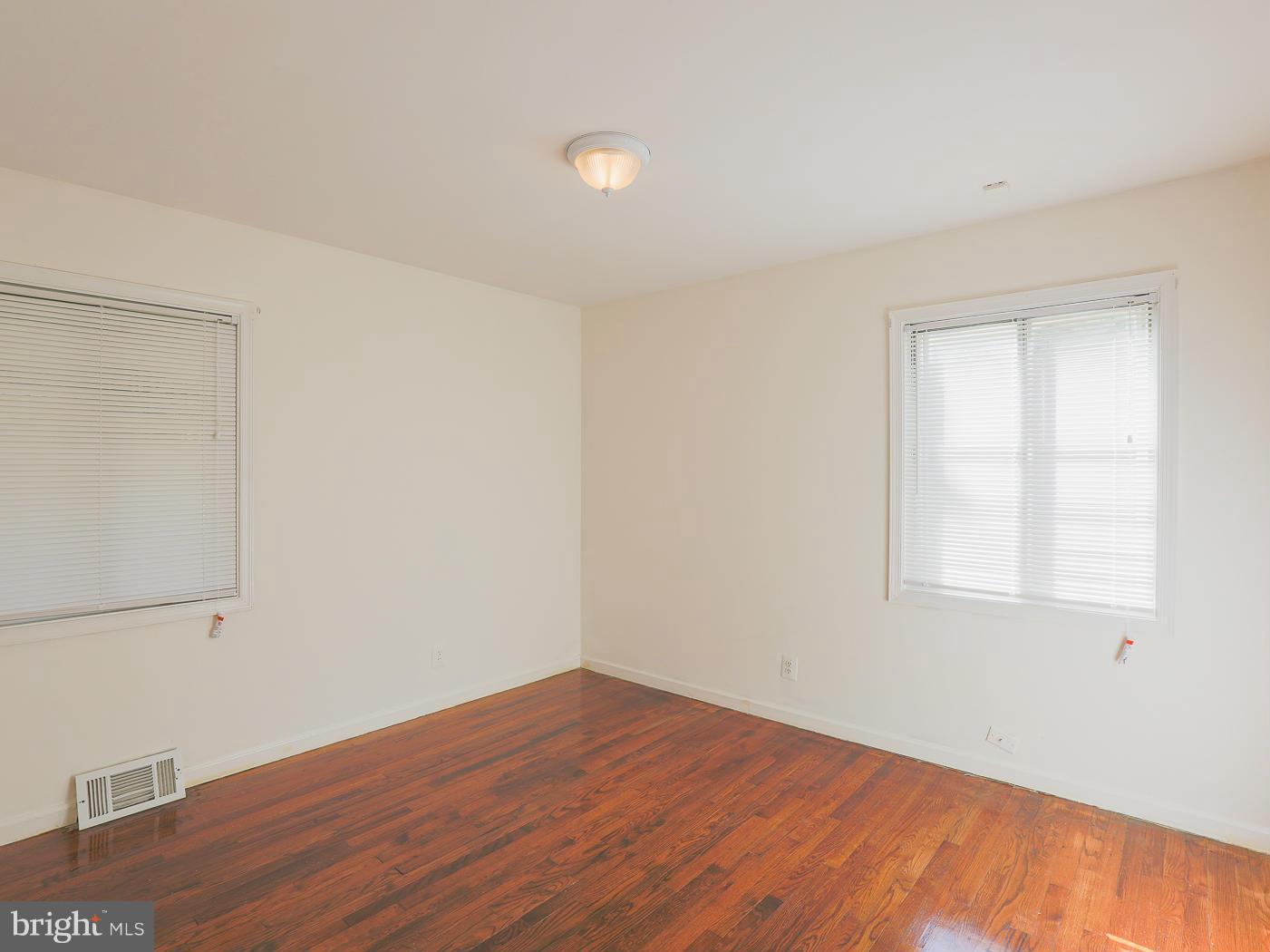 3114 Fairview Road Baltimore, MD 21207 - Photo 21 of 30 an empty room with wooden floor and windows