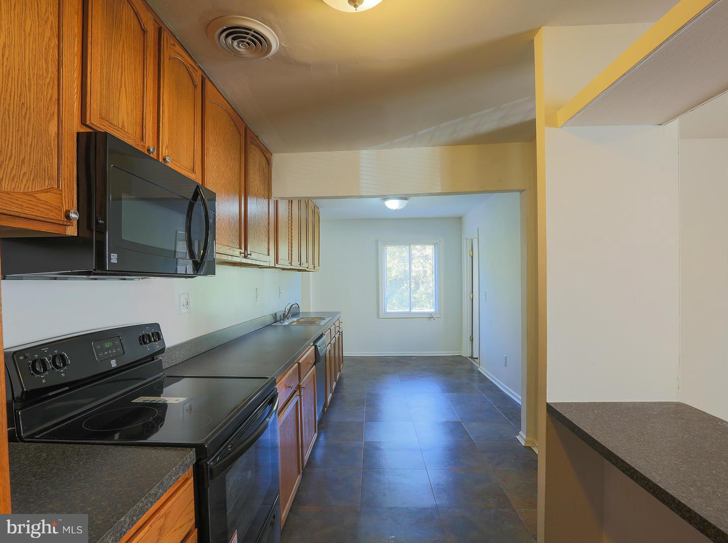 3114 Fairview Road Baltimore, MD 21207 - Photo 6 of 30 a kitchen with stainless steel appliances granite countertop a stove a sink and a microwave