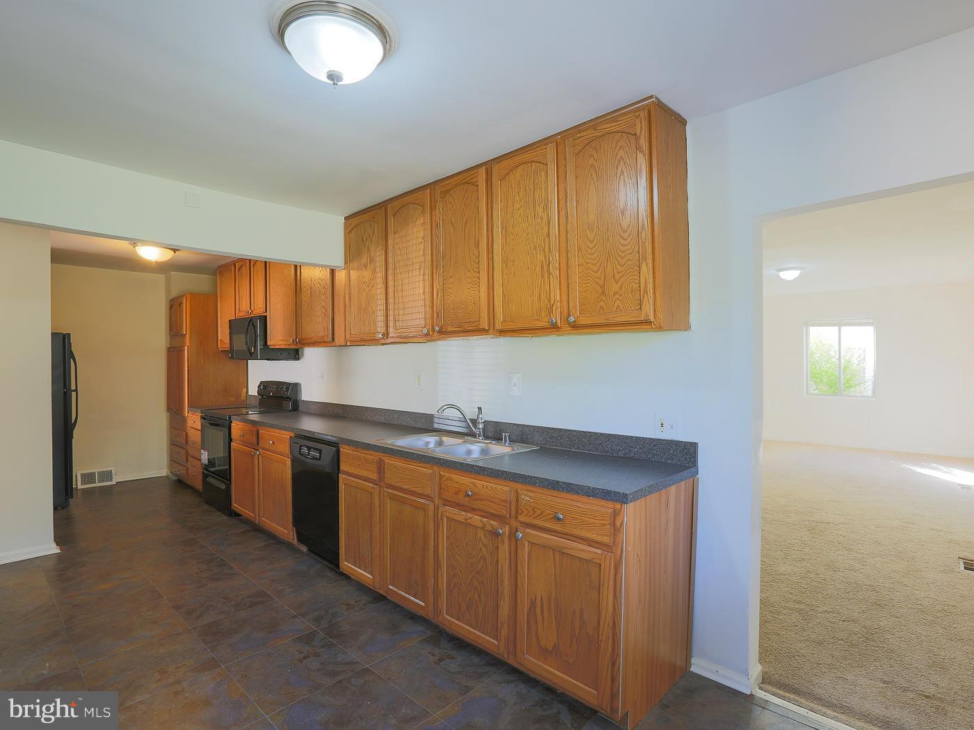3114 Fairview Road Baltimore, MD 21207 - Photo 8 of 30 a kitchen with stainless steel appliances granite countertop a sink and cabinets with wooden floor