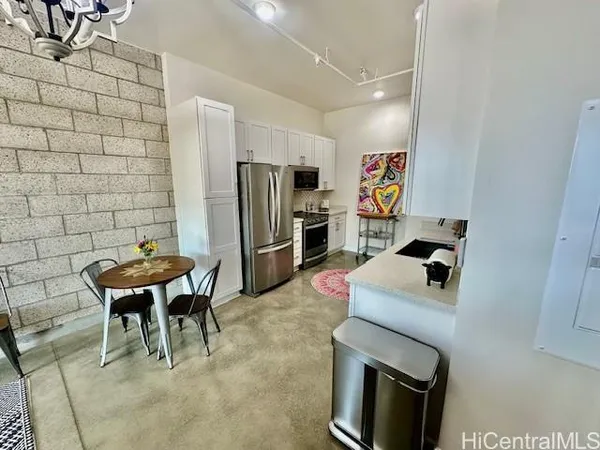 a kitchen with stainless steel appliances granite countertop a refrigerator and a stove top oven