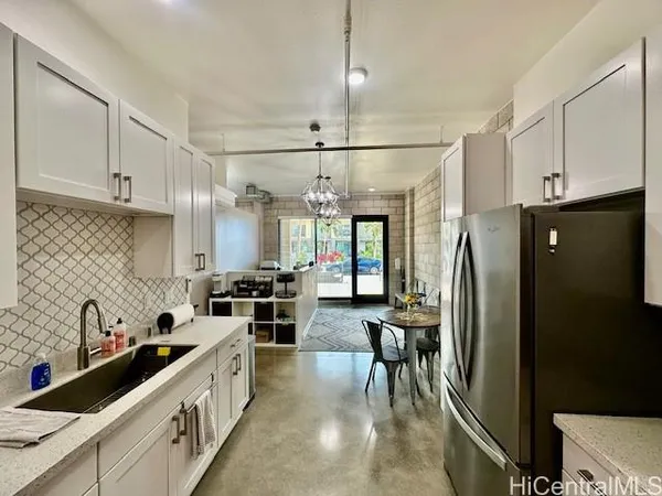 a kitchen with granite countertop a refrigerator a sink a stove and cabinets