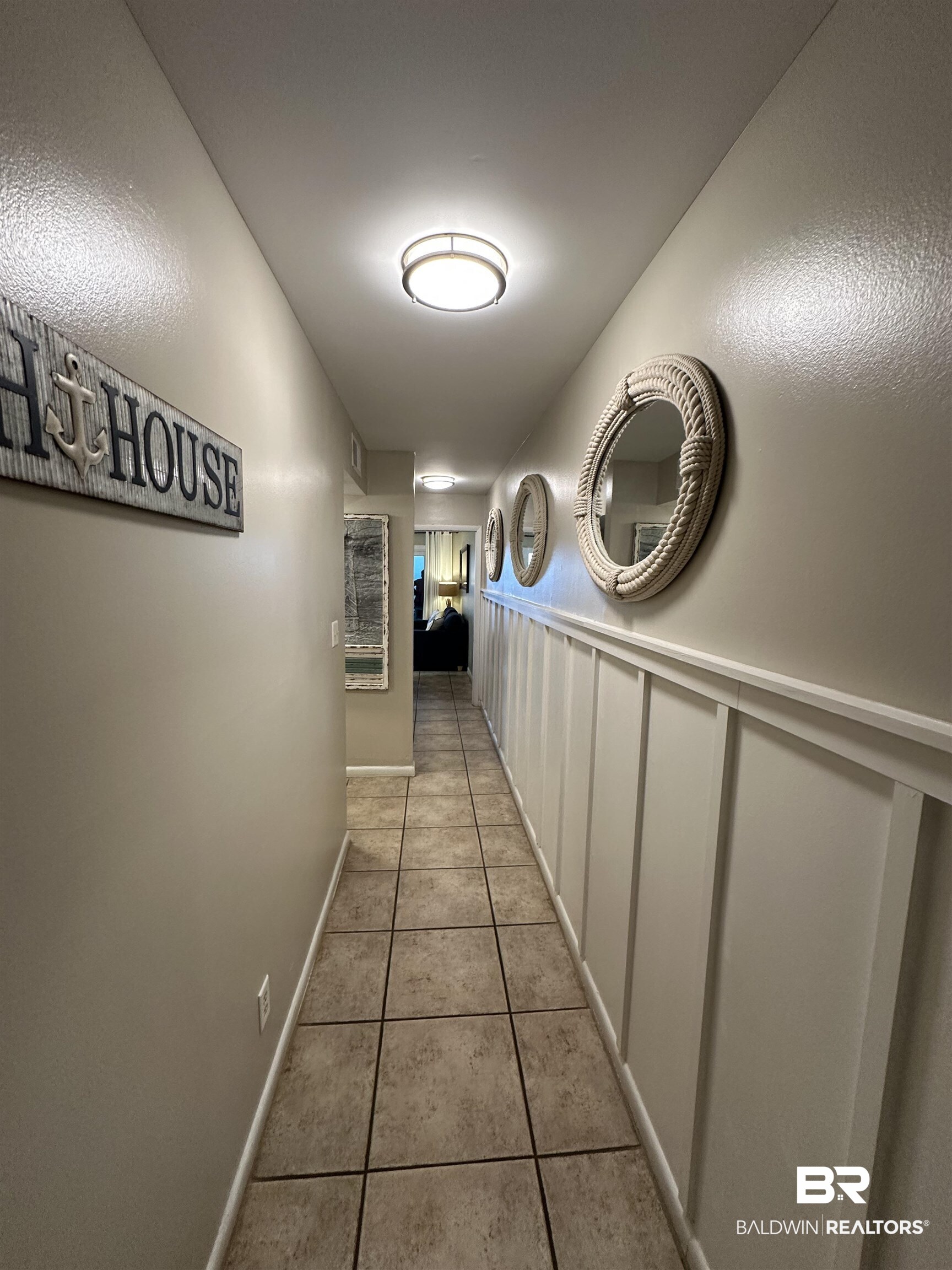 400 Plantation Road, Unit 2202 Gulf Shores, AL 36542 - Photo 24 of 26 Hall featuring light tile patterned floors, a decorative wall, and wainscoting