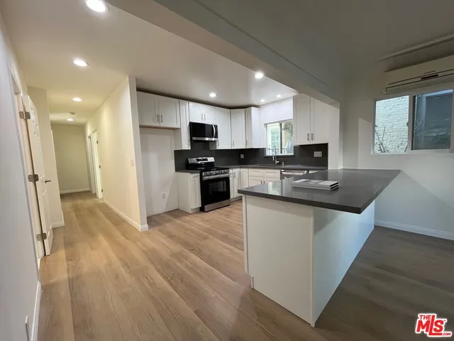 a kitchen with stainless steel appliances granite countertop a sink stove refrigerator and cabinets